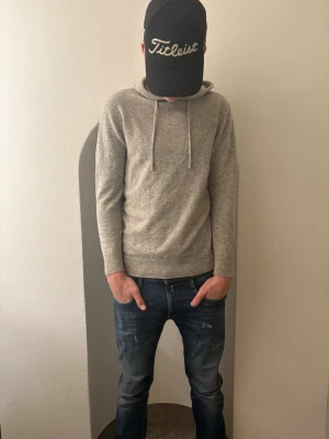 Ljusgrå hoodie i kashmir - Mjuk och stilren ljusgrå hoodie med huva och snörning. Tillverkad i en kashmirblandning som ger en lyxig känsla och passar perfekt till både chill och snygga outfits. Storleken är S. Jag är 184 och den är lite liten på mig så om du är ca runt 180 kortare eller längre så är det bara dax att lägga ut plånboken och klippa denna feta hoodien. Den är väldigt het i nuläget så passa på innan nån annan köper den.  Nypris är ungefär 800kr. Hör av dig 🤙 