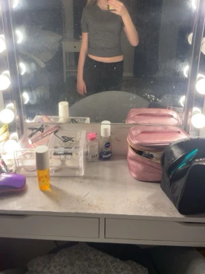 Mörkgrå croppad topp från H&M Divided - Säljer en mörkgrå croppad topp från H&M Divided i storlek XXS. Toppen har korta ärmar, rund halsringning och är ribbad nedtill. Perfekt till jeans eller kjol för en enkel och stilren look.