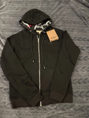 Svart Burberry Hoodie - Säljer en helt ny Burberry svart hoodie oanvänd, Storlek S Fraktar snabbt inom 24h efter köp.Ställ gärna din fråga.