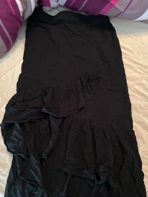 Svart långkjol med volang - Säljer en svart långkjol med snygga volangdetaljer. 