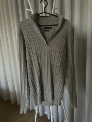 Beige stickad tröja med half zip SCW - Säljer en beige stickad tröja från SCW i storlek M. Tröjan är i nytt skick endast prövad, Tröjan har ett snyggt kabelstickat mönster, ribbade muddar och krage med half zip. Perfekt för dig som gillar klassisk stil med modern touch.
