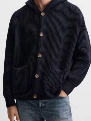 Kofta med luva - Snygg mörkblå stickad hoodie med ribbad struktur och stora fickor framtill. Finns i storlekar från S-M