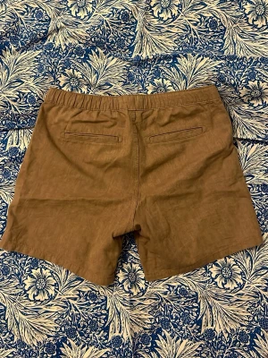 Shorts Jack & Jones - Snygga bruna shorts från Jack & Jones med elastisk midja och snörning framtill. Materialet är en skön mix av bomull och linne som passar perfekt för varma dagar. Storlek 170, passar även xs