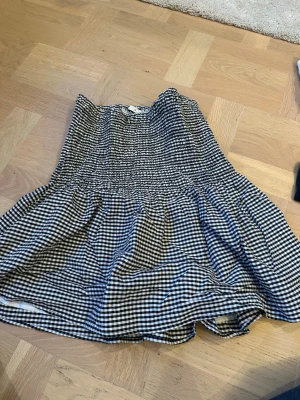 Svartvit rutig kortkjol från Cubus - Säljer en svartvit rutig kortkjol från Cubus i storlek S. Kjolen har smock i midjan och ett voluminöst fall. Pris kan diskuteras.