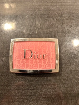 Dior Backstage Rosy Glow Rouge - Dior Backstage Rosy Glow rouge i färgen 001 Pink. Kommer i en kompakt dosa med spegel och har en intensivt rosa nyans. Pudret har Dior-logga präglad i ytan och ger en fräsch, naturlig glow till kinderna. Perfekt för dig som vill ha en poppig färg på kinderna.