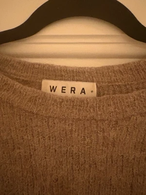 Beige stickad tröja från Wera - Mysig beige stickad tröja från Wera i storlek S. Tröjan har lång ärm och är tillverkad av en mjuk blandning av ull, alpacka, polyamid och elastan. Perfekt för kyliga dagar och har en klassisk rund hals.
