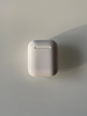 AirPods 2 - Säljer ett par Apple AirPods 2. Trådlösa hörlurar med bra batteritid och smidig anslutning till iPhone. Skicket är gott, med mindre repor på etuiet men inga synliga skador på hörlurarna. Perfekt för musik, samtal och träning.