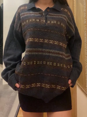 Stickad blå pikétröja (Emilio Cloud) - Säljer en oversized mörk blå pikétröja från Emilio Cloud med krage och tre bruna knappar. Materialet är stickat och känns mjukt och skönt. Perfekt för höst och vinter. OBS: vid kragen har den en liten hål som kan sys:)