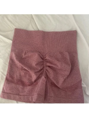 träningsshorts med scrunch - Ett par rosa träningsshorts med scrunch i storlek M 