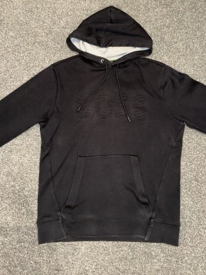 En snygg BOSS hoddie  - En snygg BOSS hoddie med en stilren text som är svart och passar med hoddien perfekt. ORGINAL ( äkta )