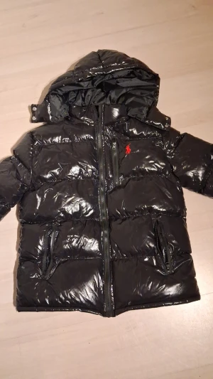 Glossy Ralph Lauren pufferjacka M - Schysst vinterjacka som värmer gott om nog inför vintern. Jackan är toppskick och finns inga skador alls. Jackan passar allt från 176-183cm och gränsen kan töjas lite. Fick denna i julklapp men tyvärr var den för stor för mig. Hör av dig om du har några frågor!
