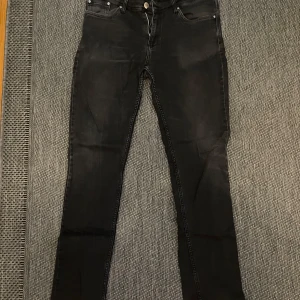 Svarta jeans från Armani Jeans - Säljer ett par svarta jeans från Armani Jeans med klassisk femficksdesign och dragkedja. Jeansen har en smal passform och är tillverkade i ett stretchigt bomullsmaterial. Perfekta för dig som gillar en stilren look med diskreta detaljer.