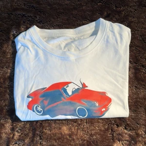 Vit t-shirt med röd sportbil Cars - Vit t-shirt med tryck av en röd sportbil och texten 'A Collection about Cars'. Klassisk passform med rund hals och korta ärmar. Perfekt för dig som gillar bilar och vill sticka ut med en cool printad tee. Gjord i mjuk bomull. Modellen är 179 65kg.  😁😁