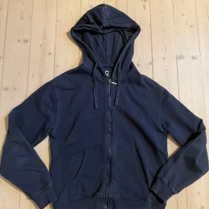  Hoodie mörblå  - Pris kan diskuteras, skriv för mer bilder! Mörkblå hoodie med huva och snörning, hel dragkedja framtill och två stora fickor. Klassisk och enkel design, perfekt för chill dagar. Mjuk bomullskänsla och ribbade muddar vid ärmslut och nederkant.