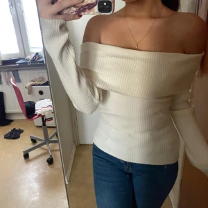 Offshoulder ribbad vit topp - Säljer en snygg offshoulder topp i ribbad vit bomull. Toppen har lång ärm och sitter tight över kroppen för en clean och stilren look. Perfekt för dig som gillar en enkel men trendig stil.