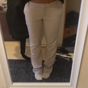 Beiga kostymbyxor från Bik Bok - Snygga beiga kostymbyxor från Bik Bok i storlek 38. Byxorna har raka ben med lätt bootcut, hällor för bälte och klassiska fickor fram. Perfekta för en clean och stilren look. Materialet känns mjukt och har en lätt stretch för extra komfort.