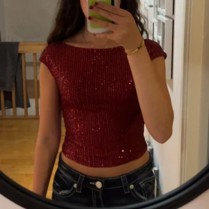 Röd glittrig topp med öppen rygg - Säljer en röd glittrig topp med öppen rygg. Jag vet tyvärr inte vart den är från då jag klippt bort lappen💞