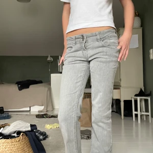 Lågmidjade Ljusgrå bootcut jeans  - Säljer ett par ljusgrå bootcut jeans med låg midja. Jeansen har dubbla knappar i midjan. Skriv för fler bilder, dem är i storlek 152 men jag som är 1,60 kan ha dem 