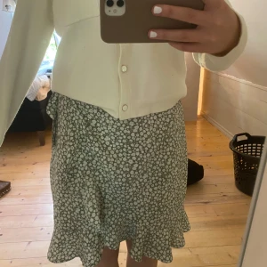 Grön blommig omlottkjol med volang - Supersöt grön midi omlottkjol från Vero Moda med volang. Knyts i sidan och har ett så bekvämt och luftigt material. Fler bilder finns att få 💕priset kan diskuteras ⚡️använd fåtal gånger 