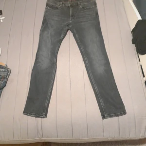 Svarta skinny jeans från Hugo 34/32 - Snygga svarta jeans från Hugo med klassisk femficksmodell och orange logopatch bak. Jeansen har skinny passform och är tillverkade i stretchig bomullsdenim för en bekväm känsla. Perfekta för dig som gillar en smal siluett och stilren look.