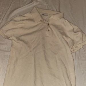 Beige pikétröja 100% merino från John Henric - Snygg beige pikétröja 100% merino  från John Henric i storlek S. Tröjan har klassisk krage, två knappar framtill och är tillverkad i ett mjukt bomullsmaterial. Perfekt för en clean och stilren look. Passar xs, priset är diskuterbart!