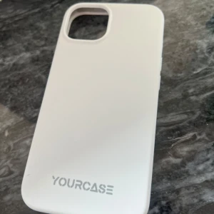 Yourcase Vit Mobilskal - Snyggt och stilrent vitt mobilskal från Yourcase. Passar iPhone-modeller med dubbelkamerautskärning. Skalet är i gott skick med minimalt slitage, perfekt för att skydda din mobil mot repor och stötar. Enkel att montera och ta av.