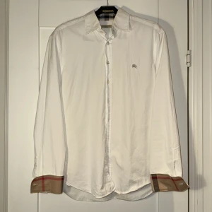 Vit Burberry skjorta storlek M - Säljer denna riktigt feta Burberry skjorta storlek M. Skjortan är nästan i helt nytt skick  utan defekter. Använd väldigt sparsamt. Modellen på bilden är 185 cm lång och väger 81kg. Nypris ca 5000, mitt pris 1049kr! Vid funderingar är det bara att höra av sig! 