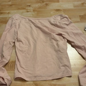 Ljusrosa långärmad topp Gina Tricot - Säljer en ljusrosa långärmad topp från Gina Tricot. Toppen har en enkel och stilren design med öppen rygg och är tillverkad i mjuk bomull. Perfekt att matcha med jeans eller kjol för en avslappnad look.