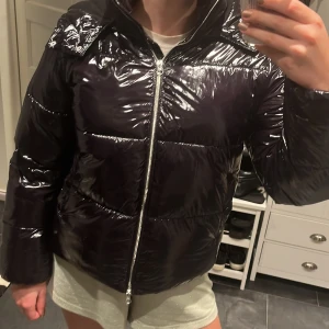 Svart glansig pufferjacka från Nelly - Säljer denna superfina jackan från Nelly då den inte används längre🥰
