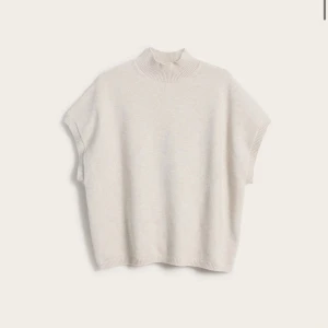 Beige stickad ärmlös polotröja - Beige stickad tröja med hög krage och ärmlös design. Aldrig använd, lappar kvar. Slutsåld online och kostade 399kr