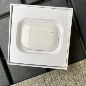 AirPods Pro - Apple AirPods Pro i originalförpackning. Trådlösa hörlurar med aktiv brusreducering och laddningsetui. Produkten ser ut att vara i gott skick med endast mindre tecken på användning. Perfekt för musik, samtal och träning.