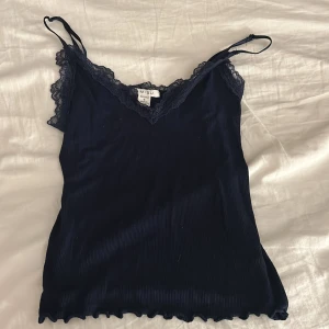 Svart ribbad linnetopp med spets AMISU - Ett mörkblått linne med spets i storlek XS från new yorker, mycket bra skick och aldrig använt 