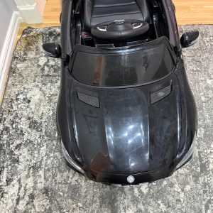 Mercedes-Benz AMG GT R elbil för barn - Snygg svart Mercedes-Benz AMG GT R elbil för barn med öppningsbara dörrar och autentiska detaljer. Perfekt för små bilentusiaster som vill köra stilfullt inomhus eller utomhus. Bilen funkar inte för tillfället då laddare saknas. 