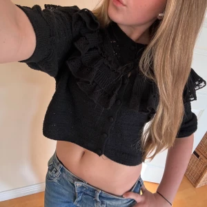 Svart croppad kofta med volang från Zara - Supersöt svart croppad kofta från Zara med volangdetaljer och spets runt axlarna. Knappt använd och i bra skick💗