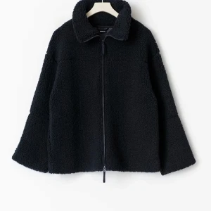 Marinblå teddyjacka med dragkedja - Mysig marinblå teddyjacka från Gina Tricot med hög krage och hel dragkedja framtill. Jackan har en loose passform och är tillverkad i mjuk fleece som håller dig varm under kyliga dagar. Perfekt för dig som gillar en enkel och stilren look.