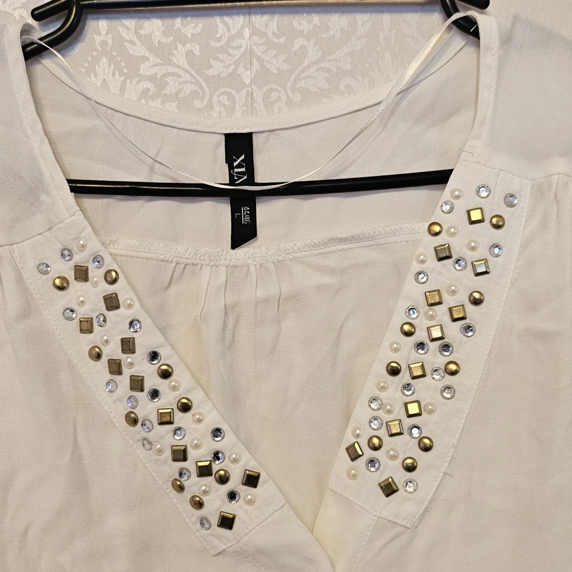 Vit blus med pärlor och nitar från VIX