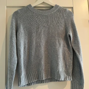 Ljusblå stickad tröja från H&M Divided - Enkel och stilren ljusblå stickad tröja från H&M Divided. Tröjan har rund halsringning, ribbade muddar och nederkant samt lång ärm. Perfekt för lager-på-lager och passar till allt. Supermjuk och skön att ha på sig.