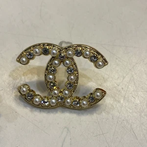  örhängen med pärlor och strass -  örhängen i guldtonad metall , dekorerade med vita pärlor och glittrande strass. Snygg statement-accessoar som lyfter vilken outfit som helst. Stift med transparent plopp för enkel användning.