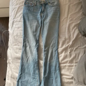 Ljusblå bootcut jeans Lågmidjade  - Säljer ett par ljusblå jeans från g perfect jeans i klassisk bootcut-modell. Jeansen har fem fickor, dragkedja och knapp framtill samt kontrastsömmar. Tillverkade i jeansmaterial och passar dig som gillar en avslappnad stil. liten repa på insidan av låret men de är inte hål. se bild 