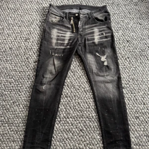 Svarta Dsquared2 skinny jeans med slitningar - Ett par svarta s jeans från Dsquared2 med coola slitningar och blekta detaljer. Skulle säga att skicket är som nytt, finns några tecken på användning. Hör av dig vid frågor!