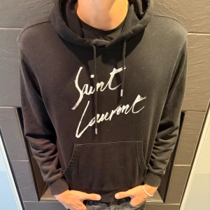 Saint Laurent Hoodie - Tjena! Säljer nu denna sjukt eftertraktade hoodien från Saint Laurent, plagget är i grymt skick och har inga tecken på användning🤩 Modellen är 186cm lång och väger 71kg! DM vid eventuella frågor!