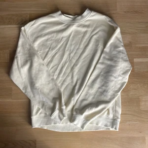 Vit sweatshirt från Monki XS - En stilren sweatshirt från Monki i storlek XS. Tröjan har rund halsringning, långa ärmar och ribbade muddar vid ärmslut och nederkant. Perfekt för en clean och avslappnad look.