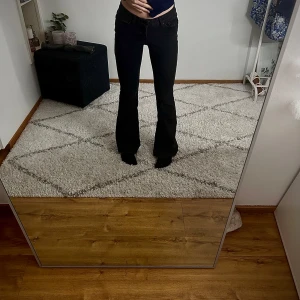 Svarta bootcut jeans från Vero Moda - Svarta jeans från Vero Moda med bootcut-modell och klassisk femficksdesign med låg midja.      