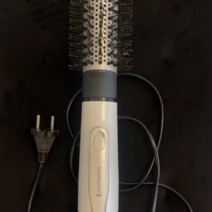 Remington varmluftsborste - Remington varmluftsborste med rund borste och sladd. Perfekt för att skapa volym och styling. Synligt i gott skick, inga större repor eller skador. Enkel att använda med en knapp för inställningar. Passar för daglig hårstyling.