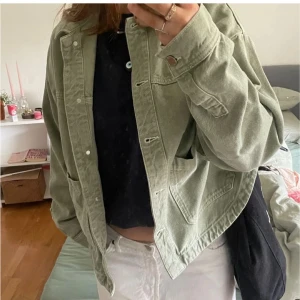 Grön jeansjacka i loose fit - Snygg ljusgrön jeansjacka med avslappnad passform och stora fickor framtill. Jackan har knappar och klassisk krage, perfekt att slänga över en t-shirt för en chill look.