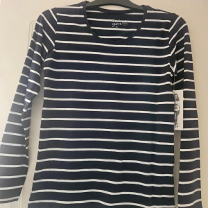 Randig långärmad tröja Basic You S - Mörkblå och vit randig långärmad tröja från Basic You. Tillverkad i mjuk ekologisk bomull med lite stretch för extra komfort. Klassisk rund halsringning och smal passform, perfekt för en clean och stilren look.