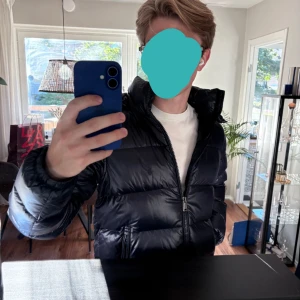 Polo Ralph Lauren Jacka Mörkblå - Säljer en mörkblå pufferjacka från Polo Ralph Lauren. Nypris 6000, köpt på Plick för 3700. Endast använd (av mig) ~3 gånger då jag inte riktigt fastnat för den. Väldigt bra skick! Jackan har glansig yta, hög krage, avtagbar huva och dragkedja framtill.  