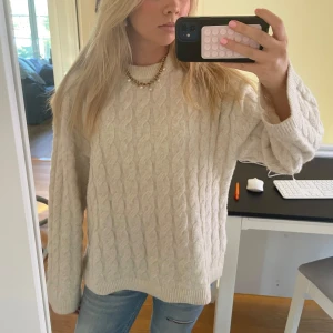 Beige kabelstickad tröja - Säljer en beige kabelstickad tröja med rund hals och lång ärm. 