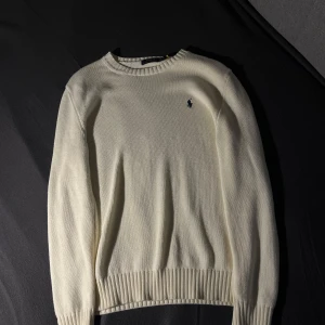 Vit/beige stickad tröja från Ralph Lauren - Vit/beige stickad tröja från Ralph Lauren till salu i okej skick, enda defekten på tröjan är ett litet hål i ryggen, annars är tröjan intakt! Hör av dig vid funderingar😀