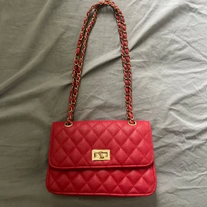 Röd väska - Röd väska med guld detaljer, lite märken vid låset